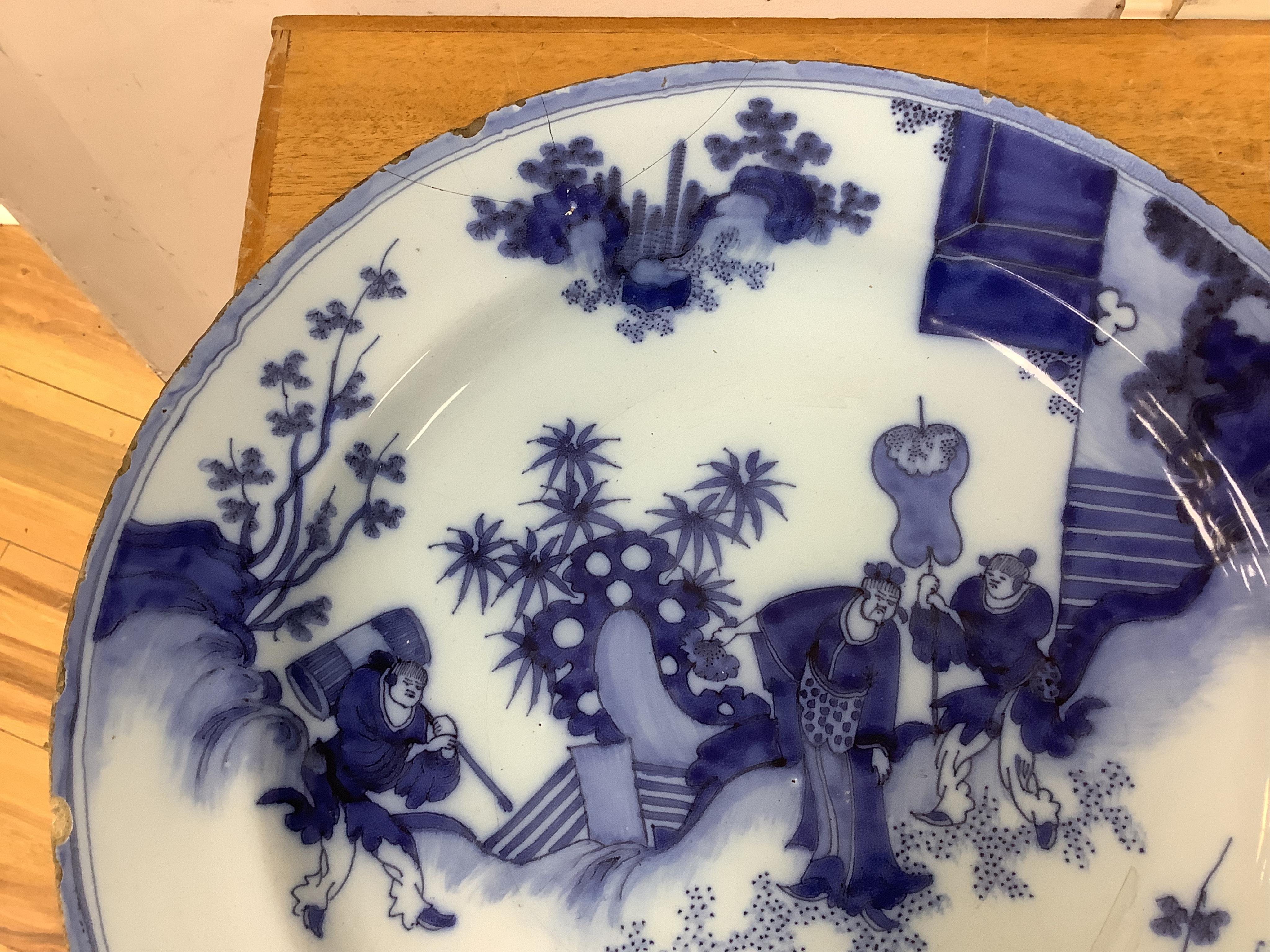 An 18th century English delftware ‘Chinese figures’ dish and two similar Delft dishes, largest 39cm diameter (3), largest 39cm